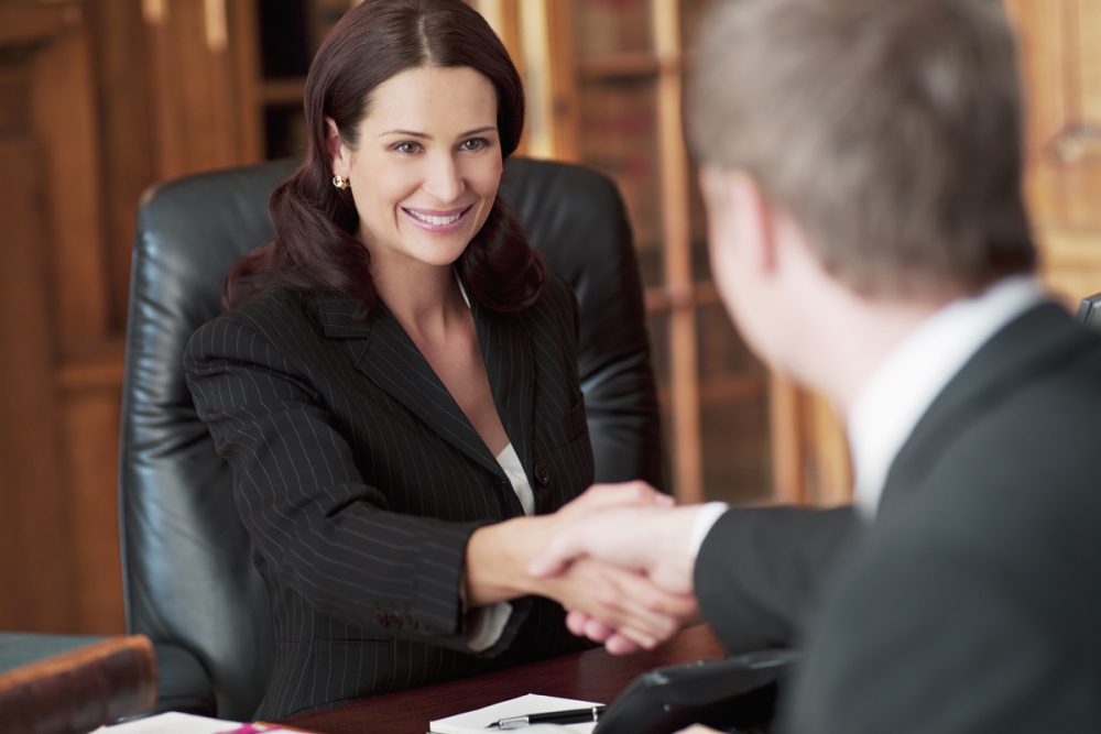 Smiling lawyers shaking hands in office